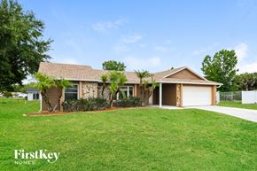 Kissimmee house for rent - a home with palm trees in front of a lawn