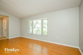 Kissimmee house for rent - an empty living room with wood floors and a window