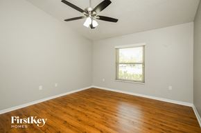 Kissimmee house for rent - a living room with wood floors and a ceiling fan