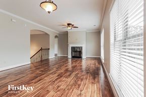 Bessemer house for rent - A spacious living room with wood flooring and a ceiling fan.