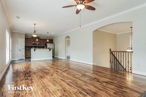 Bessemer house for rent - A spacious room with wooden floors and a ceiling fan.