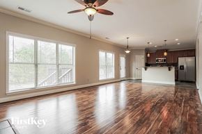 Bessemer house for rent - A spacious room with wooden floors and a ceiling fan.