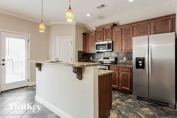 Bessemer house for rent - A kitchen with a white counter top and a stainless steel refrigerator.