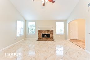Richmond house for rent - A spacious room with a fireplace and a ceiling fan.