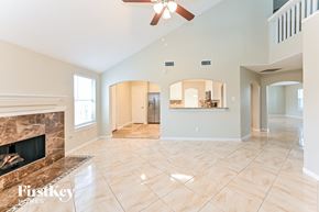 Richmond house for rent - A spacious living room with a fireplace and a ceiling fan.