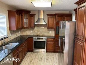 Sanford house for rent - a kitchen with wooden cabinets and stainless steel appliances