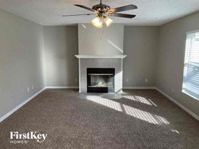 Sanford house for rent - a living room with a fireplace and a ceiling fan