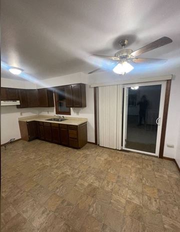 Weston apartment for rent - A kitchen with a fan and brown cabinets.