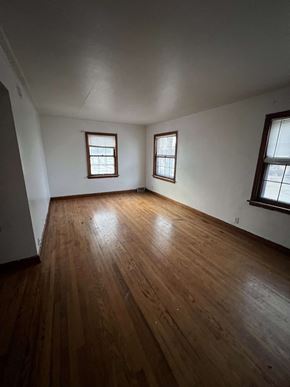 Milwaukee apartment for rent - an empty living room with wooden floors and two windows