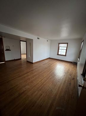 Milwaukee apartment for rent - an empty living room with wooden floors and a window