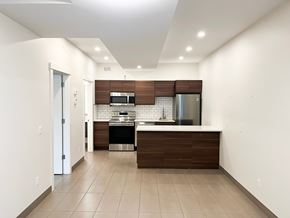 Regina apartment for rent - an empty kitchen with white walls and wooden cabinets