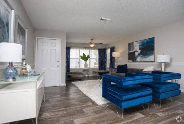 Ellenwood apartment for rent - A living room with a blue couch and a white door.