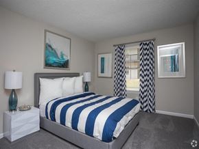 Ellenwood apartment for rent - A bedroom with a large bed and a painting on the wall.