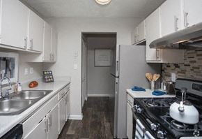 Ellenwood apartment for rent - A kitchen with white cabinets and a black stove top.