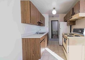 Wainwright apartment for rent - a kitchen with wooden cabinets and a white counter top