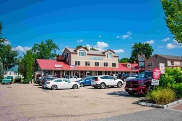 North Conway apartment for rent - a parking lot full of cars in front of a building