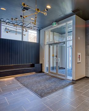 Calgary apartment for rent - A hallway with a glass door and a carpet on the floor.