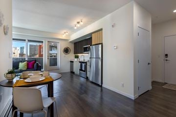 Calgary apartment for rent - A kitchen with a table and chairs in front of a window.