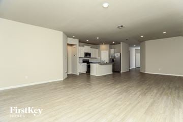 San Antonio house for rent - A spacious kitchen with white cabinets and a wooden floor.