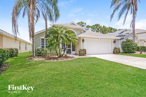 Haines City house for rent - A house with a white garage door and palm trees in front.