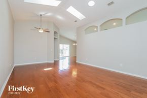 Haines City house for rent - A spacious room with wooden floors and a ceiling fan.