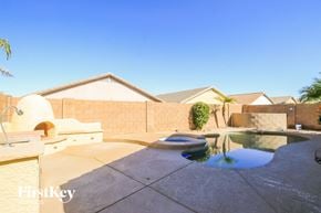 San Tan Valley house for rent - A pool in a backyard with a house in the background.