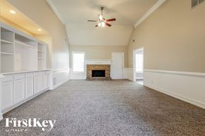 Dacula house for rent - A spacious room with a fireplace and a ceiling fan.