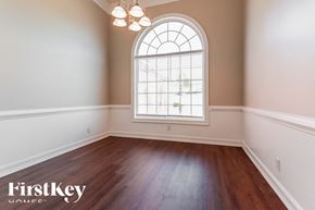 Dacula house for rent - A room with a wooden floor and a large arched window.