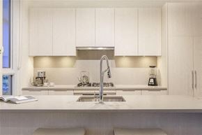 Burnaby apartment for rent - A modern kitchen with white cabinets and a stainless steel sink.
