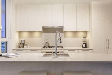 Burnaby apartment for rent - A modern kitchen with white cabinets and a stainless steel sink.