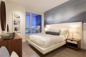 Burnaby apartment for rent - A bedroom with a large bed and a surfboard on the wall.
