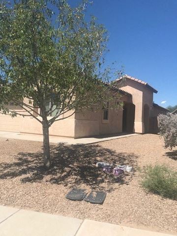 Marnaa house for rent - a house with a tree and some shoes on the ground