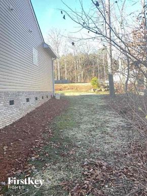 Huntersville house for rent - a backyard with a brick building and a tree