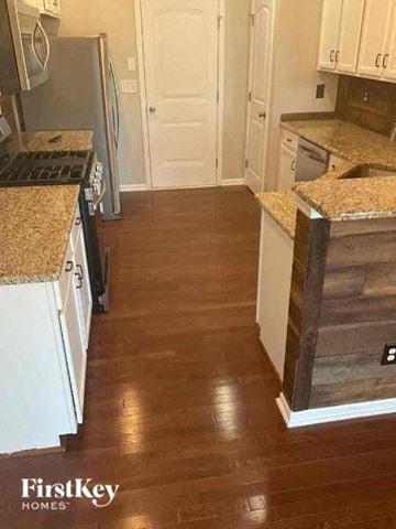 Huntersville house for rent - a kitchen with white cabinets and a wood floor