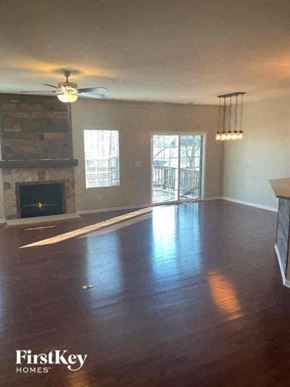 Huntersville house for rent - an empty living room with a ceiling fan and a fireplace