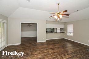 Cordova house for rent - A spacious room with a ceiling fan and wooden flooring.
