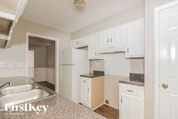 Cordova house for rent - A kitchen with white cabinets and a sink.