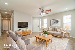 Gilbert house for rent - A living room with a grey couch, a wooden coffee table, and a ceiling fan.