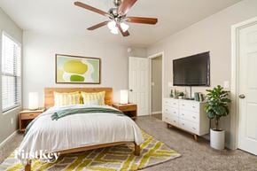 Gilbert house for rent - A bedroom with a bed, a dresser, a ceiling fan, and a painting on the wall.