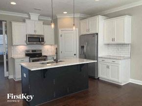 Charlotte house for rent - a kitchen with white cabinets and a counter top
