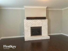 Charlotte house for rent - a fireplace in a living room with a wooden floor