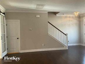 Charlotte house for rent - an empty living room with a white door and a staircase