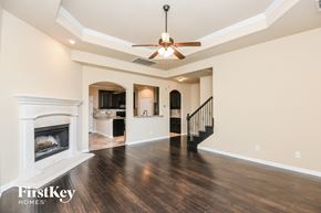 Fort Worth house for rent - A spacious living room with a fireplace and a ceiling fan.