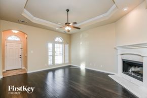 Fort Worth house for rent - A spacious living room with a fireplace and a ceiling fan.