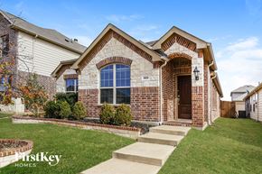 Aubrey house for rent - the front of a brick house with a lawn and steps to the front door