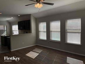 Aubrey house for rent - an empty living room with a ceiling fan and windows
