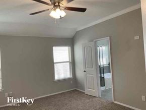 Aubrey house for rent - a bedroom with a ceiling fan and a door to the bathroom