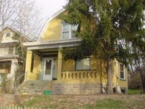 Cincinnati house for rent - A yellow house with a tree in front.