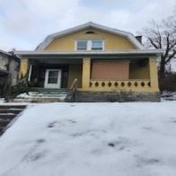 Cincinnati house for rent - A yellow house with a white door and a brown window.