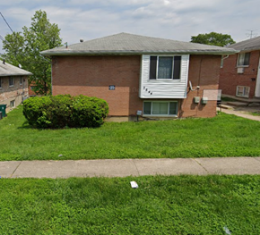Cincinnati apartment for rent - A brick house with a green bush in front.